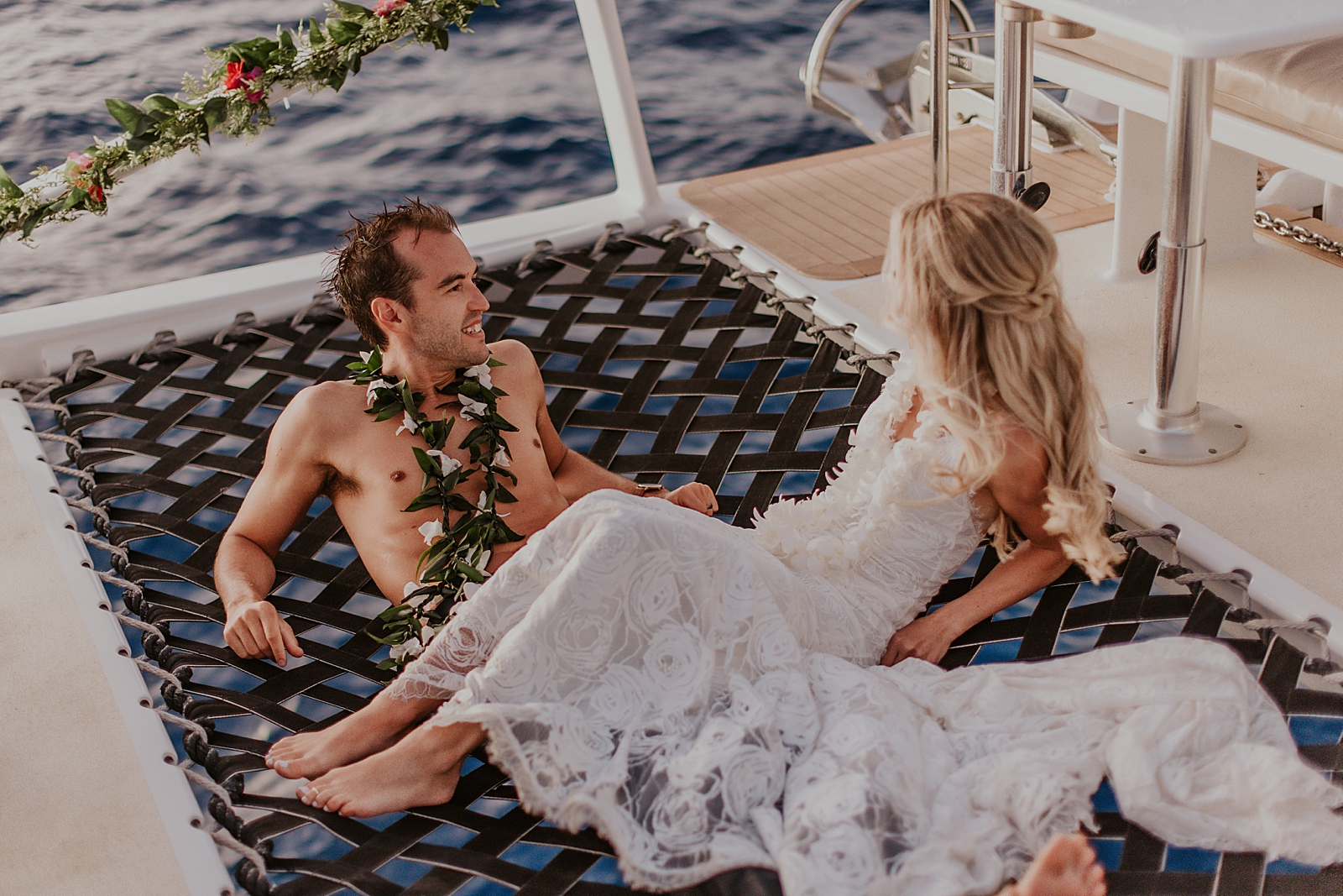 Bride and Groom laying together on canopy floor of the boat